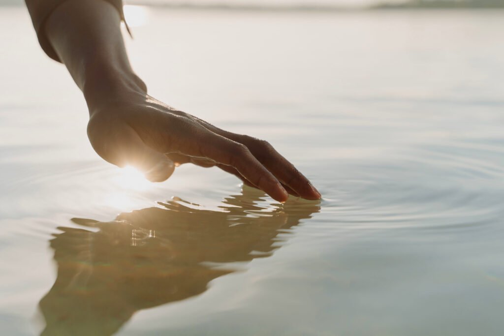 Una mano sfiora delicatamente la superficie dell'acqua