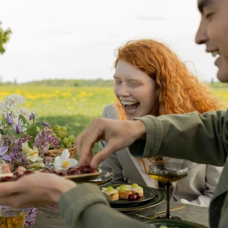 Persone sorridenti che condividono il cibo all'aperto